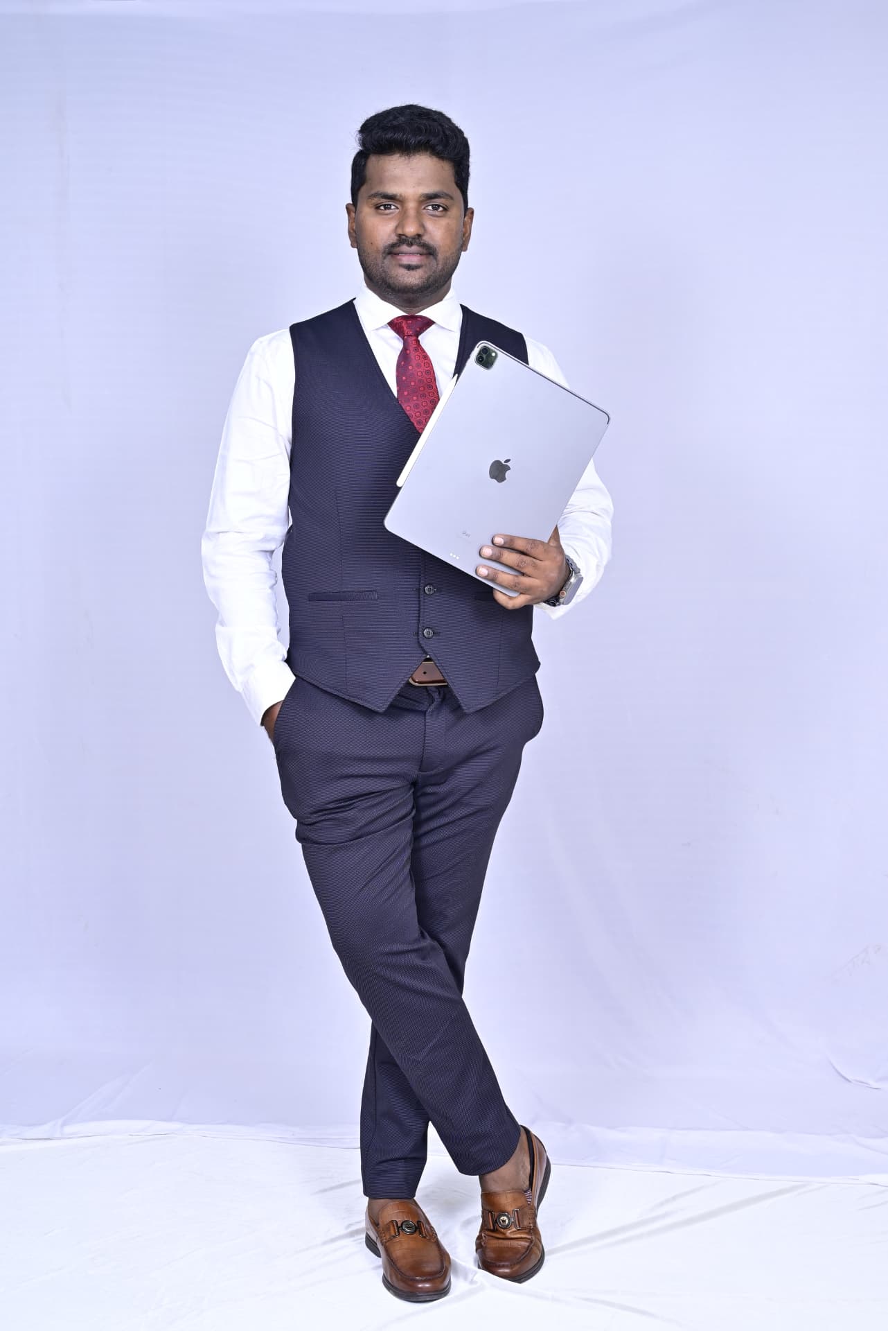 Dr. Ramesha A. in a navy waistcoat holding an iPad