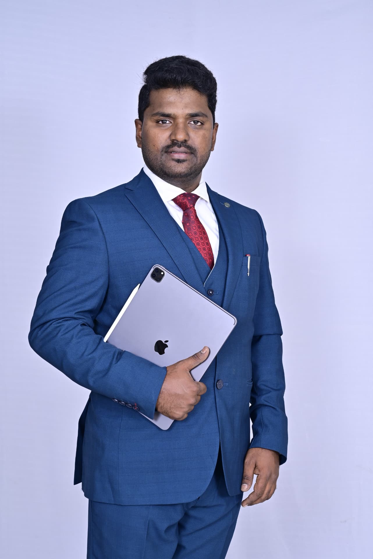 Dr. Ramesha A. in a blue suit holding an iPad